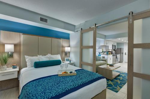 代托纳海滩埃克斯瑞格兰德海洋度假村的一间卧室配有一张床,另一间卧室配有厨房