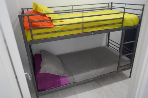 大加那利岛拉斯帕尔马斯Coworking Studio的双层床,配有不同的彩色床单