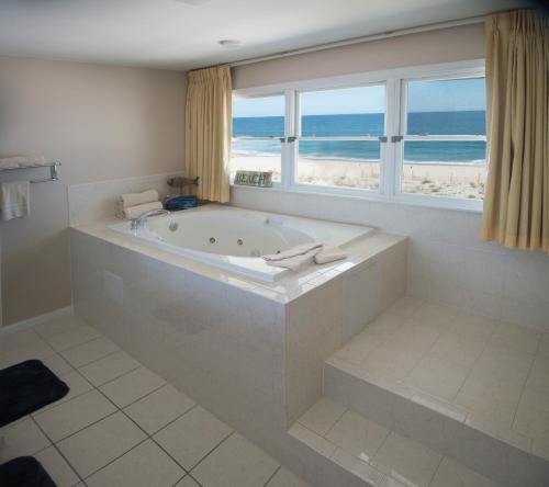 希普博特姆Drifting Sands Oceanfront Hotel的一间带浴缸的浴室,享有海滩美景