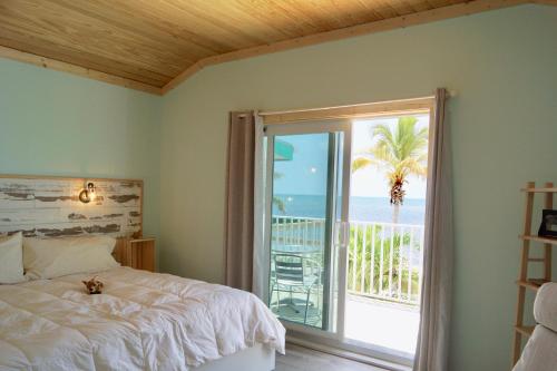 大松礁岛Deer Run on the Atlantic的一间卧室设有一张床和一个享有海景的窗户。