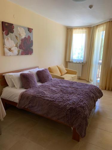 波罗维茨Studios-Villa Park SV的一间卧室配有一张紫色的床和一张沙发