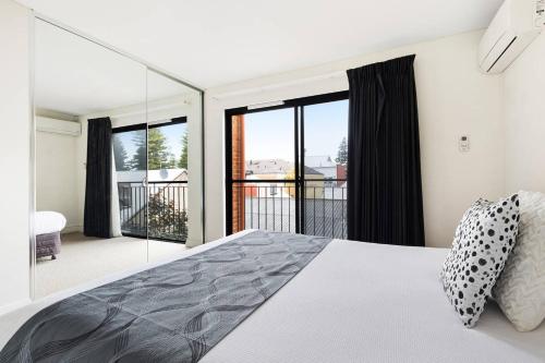 弗里曼特公园巷公寓的一间卧室设有床铺和大型玻璃窗