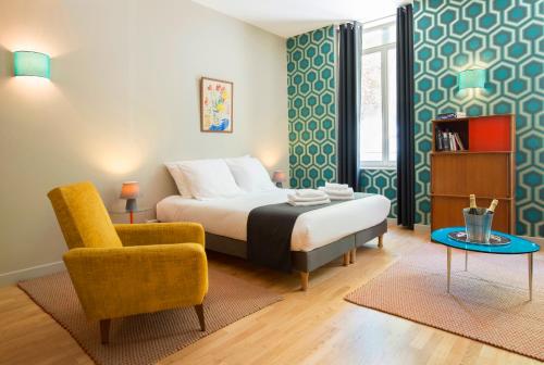 巴黎赫尔沙尔香榭丽舍套房及酒店的一间卧室配有一张床、一把椅子和一张桌子