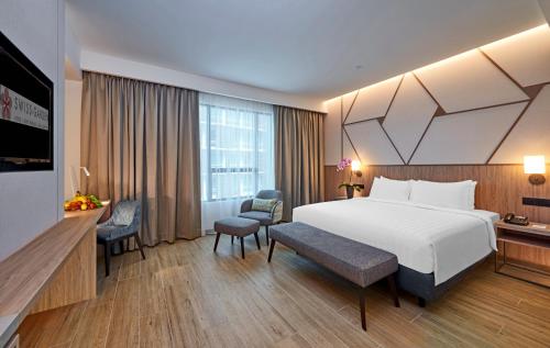 吉隆坡Swiss-Garden Hotel Bukit Bintang Kuala Lumpur的酒店客房设有一张白色大床和一张书桌
