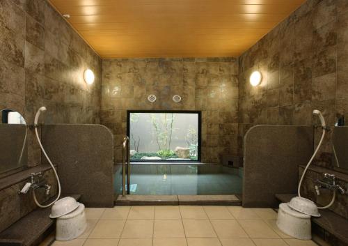 半田半田龟崎茹特酒店的一间带游泳池及两个卫生间的浴室