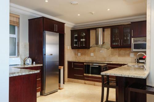 巴利托Ballito Manor Beach 405 - FAMILY ONLY - With Generator的厨房配有木制橱柜和不锈钢冰箱。