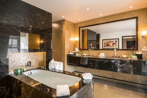 布鲁塞尔布鲁塞尔大广场华威酒店的一间带浴缸和大镜子的浴室