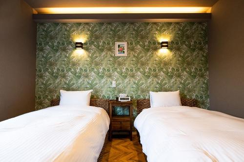 石垣岛Alezed Villa Shiraho的两张睡床彼此相邻,位于一个房间里