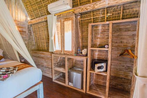 蓝梦岛恍惚湾别墅度假村的木墙、床和窗户的房间