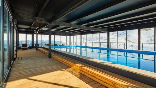 古多里Gudauri Loft Hotel的一座大型游泳池,位于一座带窗户的建筑内