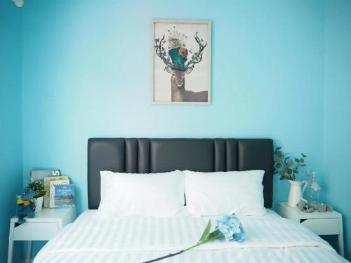 曼谷Makkasan Happy Home的一间卧室配有一张蓝色墙壁的床