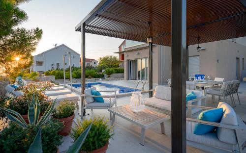 赫瓦尔Villa Moderna Family Friendly的一个带桌椅的庭院和一个游泳池