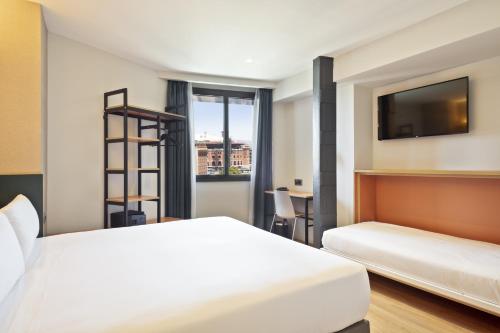 巴塞罗那Hotel Brick Barcelona的酒店客房设有两张床和一台平面电视。