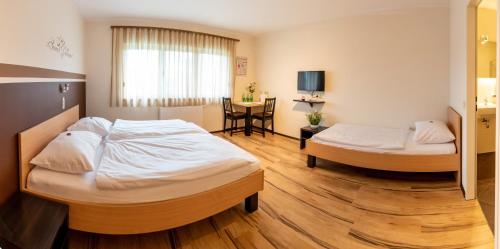 门希霍夫Gästehaus Moser的酒店客房设有两张床和一张桌子。