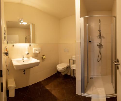 门希霍夫Gästehaus Moser的一间带水槽、淋浴和卫生间的浴室