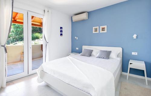 莫鲁纳特Apartment Levanat的白色卧室设有蓝色的墙壁和床