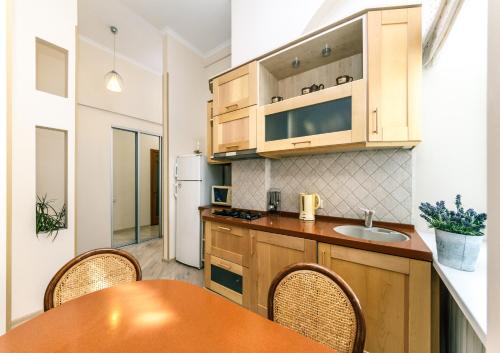 基辅Квартира на Пушкінській的厨房配有木制橱柜和桌椅
