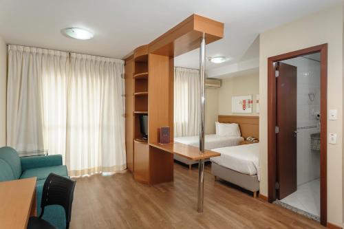 奥萨斯库尊贵酒店的酒店客房设有一间带一张床和一张沙发的卧室