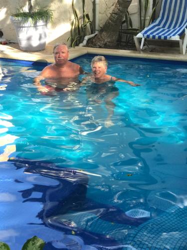 莫雷洛斯港阿马尔酒店的两个男人在游泳池游泳