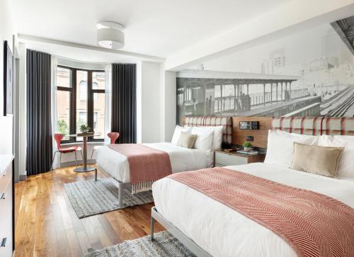 波士顿The Revolution Hotel的酒店客房配有两张床和一张书桌