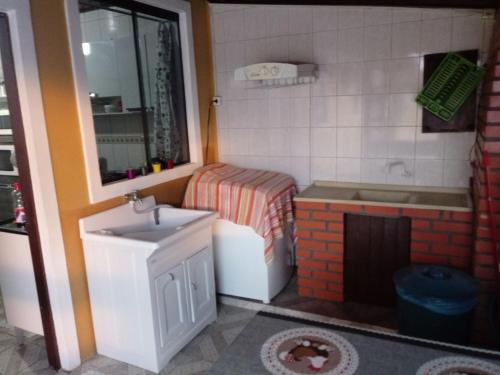 弗洛里亚诺波利斯Pousada Residencial Caroa的设有带水槽和浴缸的玩具浴室