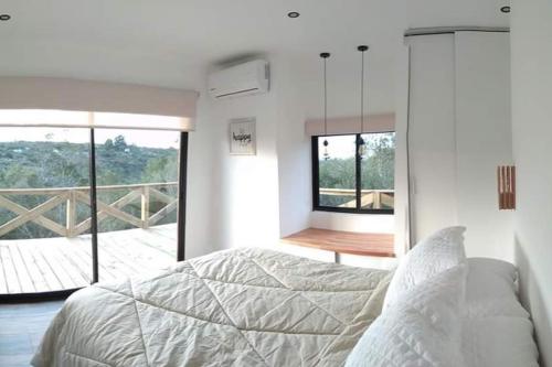 塞拉纳镇Villa Serrana Relax & Confort的一间卧室设有一张床,享有阳台的景色