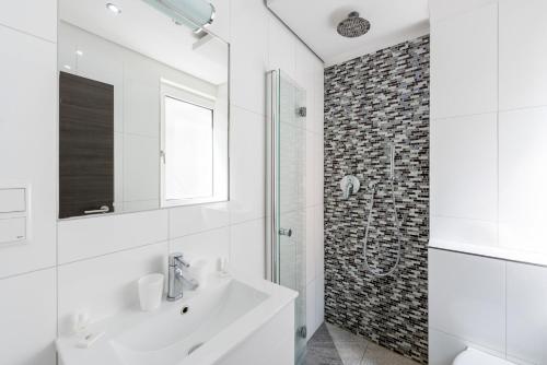 科隆布尔格霍夫酒店的白色的浴室设有水槽和淋浴。