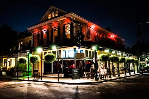 新奥尔良Royal Street Inn & Bar的一座建筑,人们在晚上坐在外面