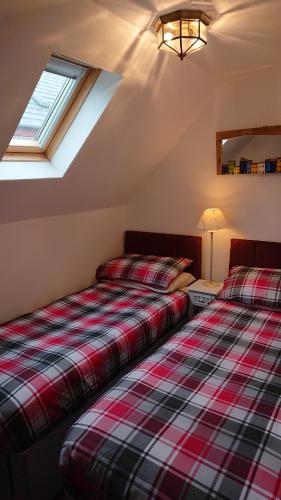 奈恩Seaforth Cottage.的两张睡床彼此相邻,位于一个房间里