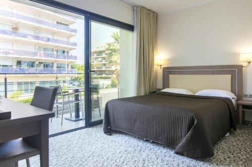 卢贝新城蓝色别墅酒店的酒店客房设有一张床和一个阳台。