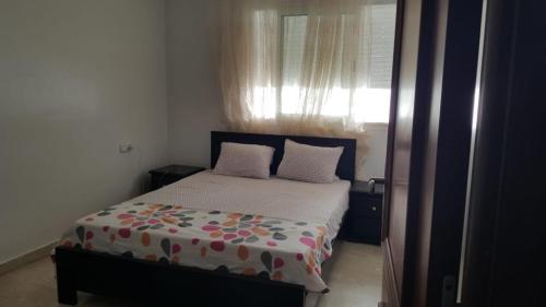 拉巴特apartment 2 bedrooms in agdal的一间卧室配有带两个枕头的床和窗户