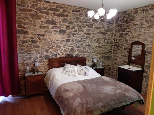 VilarA Casa do Ferrador的一间卧室设有一张床和石墙