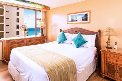 檀香山Tropical Escape, Ocean Views Condo with Parking的一间卧室设有一张大床和一个窗户。