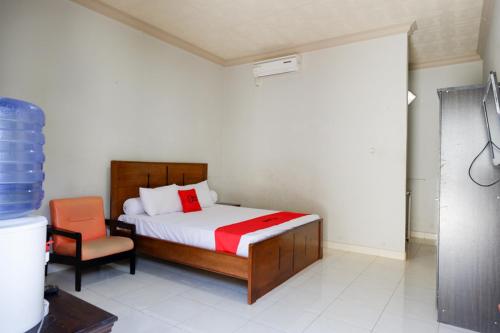 帕卢RedDoorz near Mutiara SIS Al Jufrie Airport Palu的一间卧室配有一张床和一把椅子