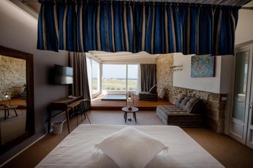 特拉帕尼艾姆里尼度假酒店的一间带大床的卧室和一间客厅