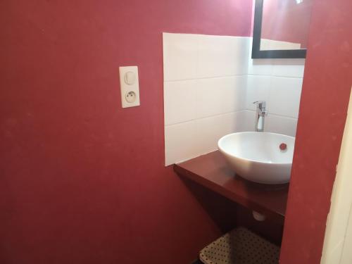 ÉpothémontLes attelages de la fontaine的浴室设有白色水槽和红色的墙壁