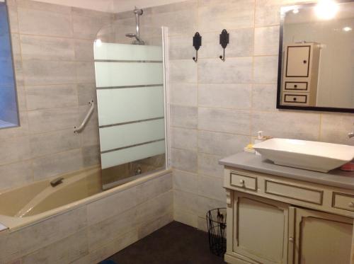 塞里尼昂-迪孔塔Gîte la Genestière的浴室配有水槽、淋浴、浴缸和镜子