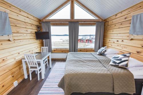 伊纳利伊纳里渡假村酒店的一间卧室配有一张床、一张书桌和一个窗户。