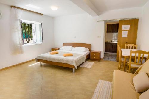 科尔丘拉Villa Ivanka的一间卧室配有一张床铺和一张桌子,还设有一间厨房