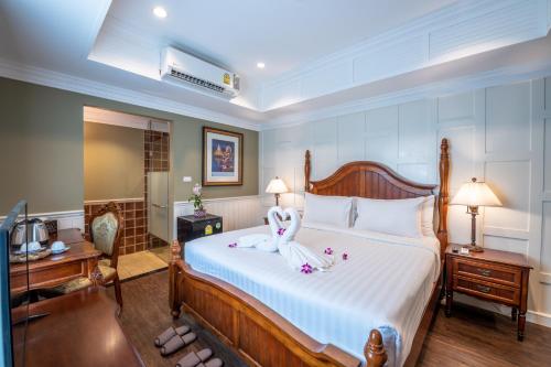曼谷153号兰花屋度假酒店的一间卧室配有一张床,床上有毛巾