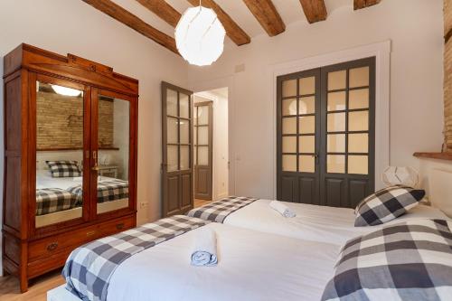 潘普洛纳El Roblón de la Estafeta的一间卧室设有两张床和木制橱柜