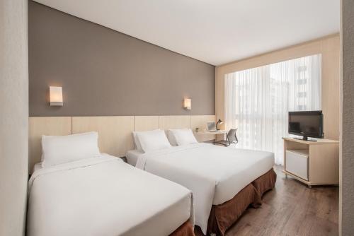 弗洛里亚诺波利斯因特城市酒店客房内的一张或多张床位