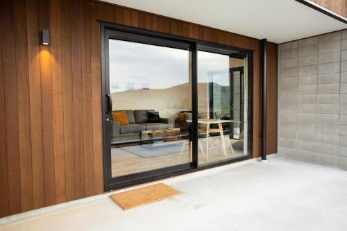 特卡波湖Wahi Nui的客厅设有滑动玻璃门,可通往庭院