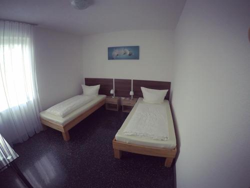 绍恩多夫Gästezimmer Faut的小房间设有两张床和窗户