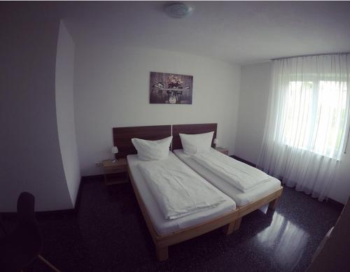 绍恩多夫Gästezimmer Faut的一间卧室配有一张带白色床单的床和一扇窗户。