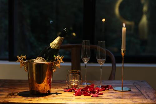 成都木来精品酒店的一张桌子,配有两瓶香槟和两杯葡萄酒
