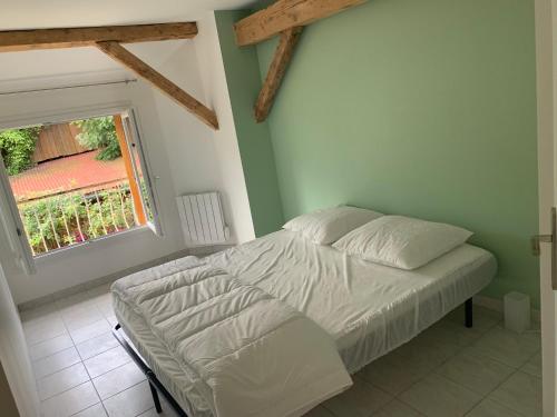 Vaulnaveys-le-HautLa grange de mémé Yvette的卧室内的一张床位,带窗户