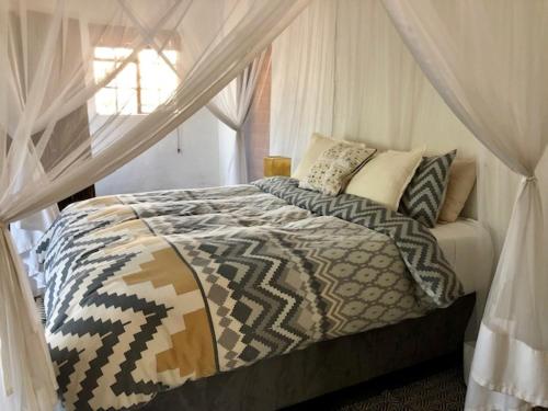 玛洛斯帕克Villa Leopards Lookout的一间卧室配有一张带天蓬的床