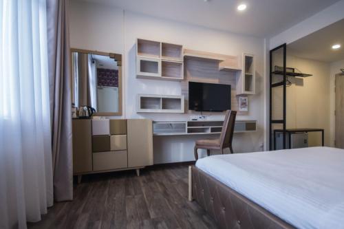 乔治市Wifi精品酒店的一间卧室配有一张床、一张书桌和一台电视。