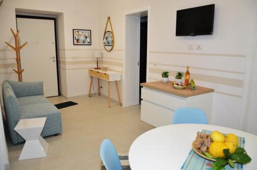卡塔尼亚Zenzero e Limone的客厅设有厨房和带一碗水果的桌子